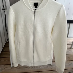 Gräddvit zip - Cool gräddvit zip i räfflat mönster. Nypris: 400 kr.