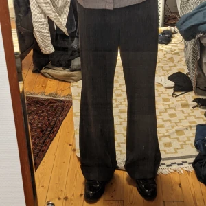 Utsvängda kostymbyxor  - Ett par riktigt snygga gråa randiga utsvängda kostymbyxor i bra skick! Kan mötas upp i Stockholm eller frakta 