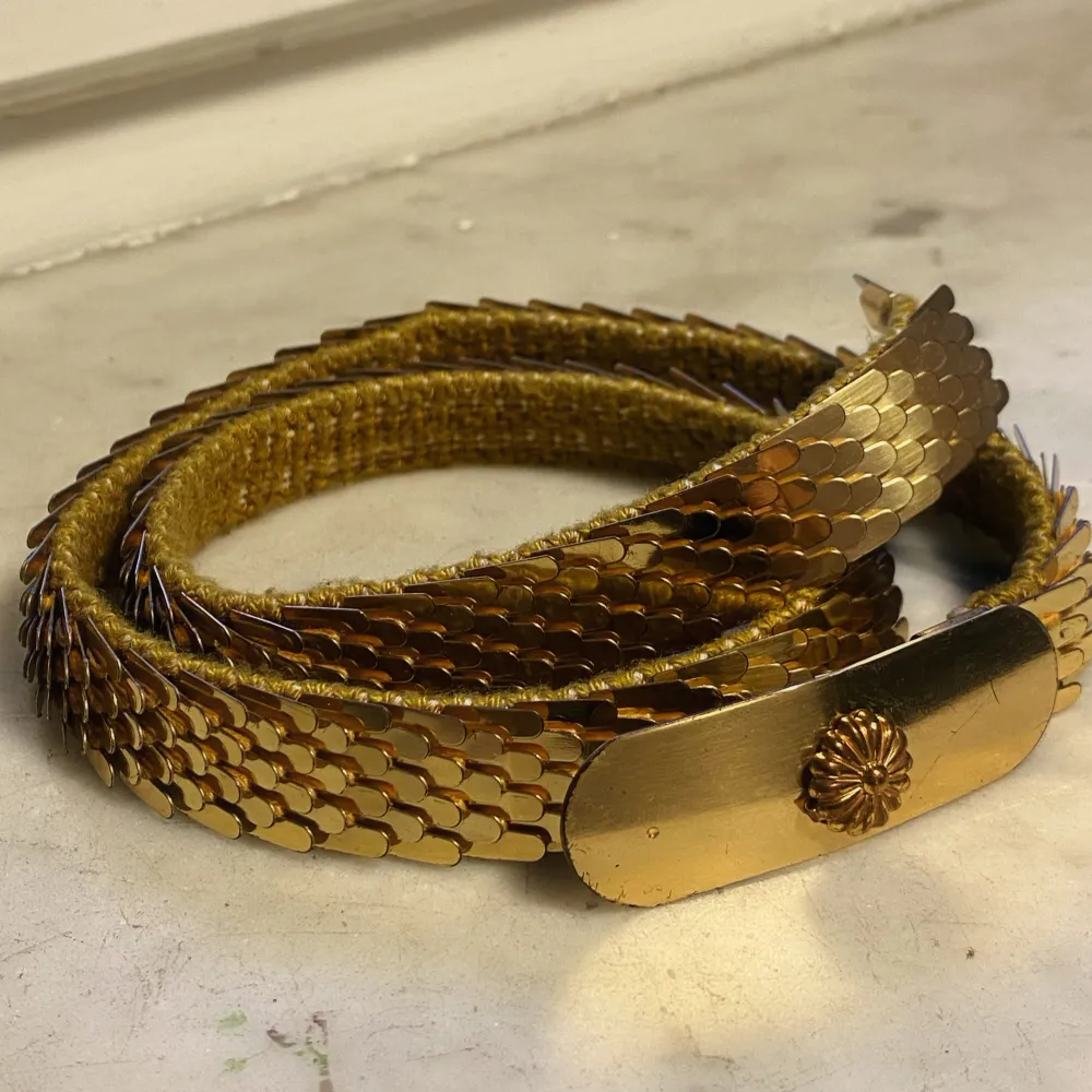 Y2K design Golden metal belt  Stretchy fabric behind metal Ca 67 cm long  Fits sizes XS and S    In good vintage condition as seen in pictures  DM me if you have questions or want to buy   Y2K guldig metallic bälte  Vintage bälte . Accessoarer.