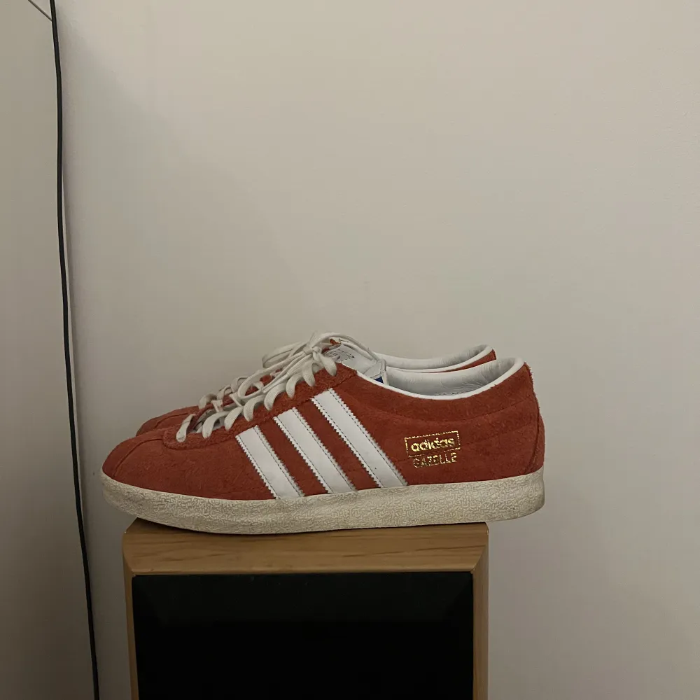 Adidas gazelle som är rödvita, skorna är använda men inget fel på dem!. Skor.