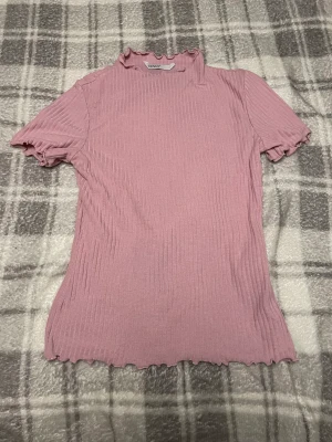Topp - Rosa topp med detaljer vid hals,ärmar och midja, högre krage. Fint skick, storlek small, fint skick.