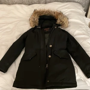 Woolrich jacka  - Säljer denna svarta woolrich jackan den e ganska använd med sista tiden kommer den inte till användning så säljer den så den kan komma till användning!