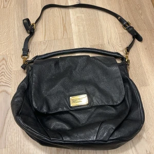 Marc Jacobs väska i skinn - Äldre marc jacobs väska, sliten men har många år mer att ge. Missfärgat foder i väskan. 