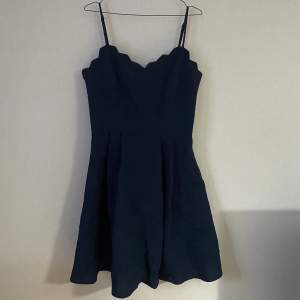 Mörkblå klänning från Nelly i storlek 40 med justerbara axelband, nypris 449kr. Bara använd en gång på en skolavslutning och har sedan dess legat i garderoben. Kan skicka fler bilder om det önskas!