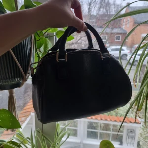 Svart axelremsväska - Svart axelvämsväska med små söta handtag. Jättefin. Använt ett fåtal gånger men som ny. Jättesnygg. Säljer för 80kr + frakt💕💕