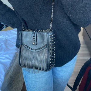 Väska med nitar! - Hej! Säljer denna så coola väska med nitar och lite annat kul! Jätte söt med avtagbara band och massa små fack inuti💜Använd endast 2 gånger💗 (allt på min plick kan fås billigare om du köper mer saker!) 