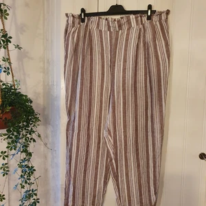 Byxor randiga storlek XXL - Härliga, bekväma, oversized byxor i XXL. Finns ögglor för skärp. Kan stylas snyygt med en vit topp för att va mer uppklädd annars sköna att gå omkring i hemma. Luftigt material som andas bra.