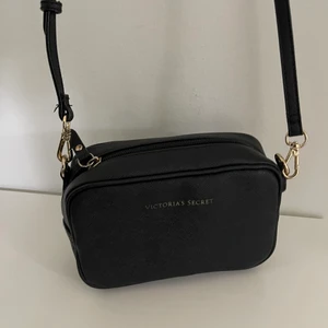 Axelremsväska från Victoria Seacret - Liten väska som passar bra till vardagliga looks eller till en kvälls middag på stan. I väskan finns ett smidigt fac, varav väskan även går att försluta med ett axelband 