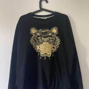 En svart kenzo tröja med guld tryck. 