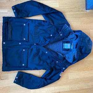 Fjällräven Greenland jacka i dunder skick! - Greenland vinterjacka från Fjällräven i svart med grå insida. Är väldigt skön, snygg och perfekt för kalla vintrar. Jackan köptes för ett par år sedan och har använts endast ett fåtal gånger och är i nyskick Nypris 3700