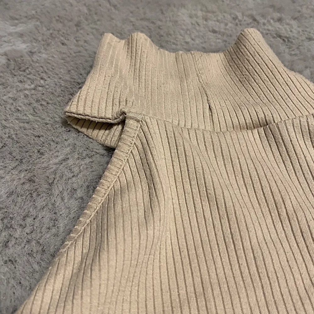 En ribbad topp med en bar axel i färgen beige.. Muu.