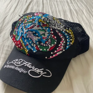 Ed Hardy keps - Ed hardy keps med rhinestones, lite trasiga sömmar på sidan av kepsen men annars sitter den bra