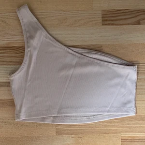 Beige One-shoulder topp - Beige One-shoulder topp.  Helt oanvänd.  Köpare står för frakt. Hör av dig vid intresse.