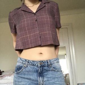 Rutig topp - Säljer denna croppade, rutiga skjort/toppen ifrån UrbanOutfitters. Har fyra knappar dock två inte syns i bilden. Användts kanske 2 gånger Max och i topp skick🌟