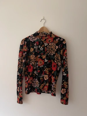 Tröja - Blommig träja med en liten polo från Monki. Använd fåtal gånger