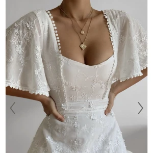 Vit somrig klänning - Helt ny, provat en gång och kostade 699. Fin klänning till student tex, dragkedja i ryggen finns. 