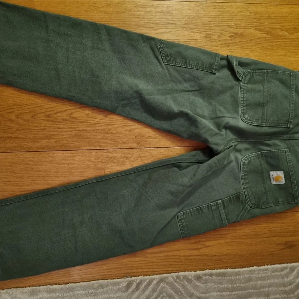 Ett par Carhartt Double Knee byxor i ”box wood green”. Byxorna är i storlek 27x32 och i jätte bra skick!. Jeans & Byxor.