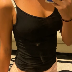 svart justerbart linne - ett svart lite V-ringat linne i storlek S. jätteskönt o ganska tunt. tror köpt på h&m eller new yorker men lappen är borta så vet ej helt säkert. står ej för frakt! 