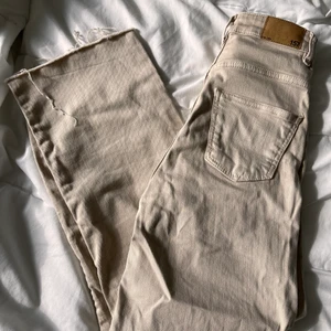 Beigefärgade jeans  - Jeans i beigefärg, ankellängd på mig som är 170cm. Hög midja, vida ben. Strl XXS, motsvarar 24 i midja. Säljes pga för små för mig. 