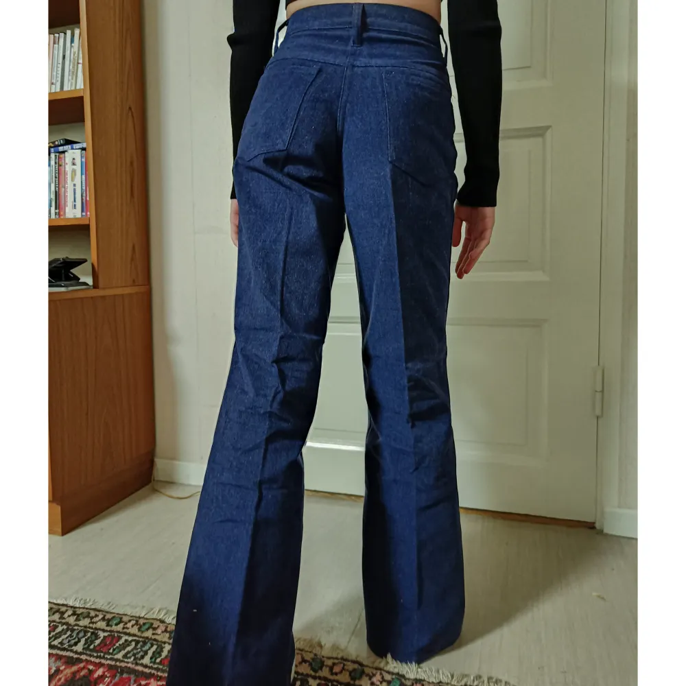 Säljer dessa fina högmidjade byxor som gjordes på 70-talet och aldrig har använts! De är 64 cm i midjan och 80 i längden, vilket motsvarar typ xs, men har även massa andra storlekar så det är bara att höra av sig!💗. Jeans & Byxor.