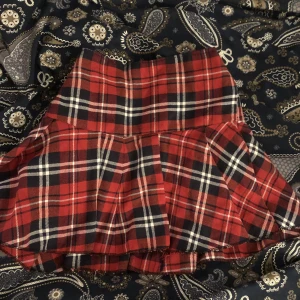 Röd pläd kjol - Super fin pläd kjol! Den har stretchig midja, så är ”resizable”.Säljer för att jag har två likadana. Har ingen anning vart jag fått den från. Fråga mig gärna om mått om du är intresserad :)