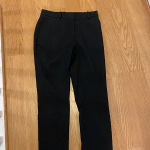 Lågmidjade kostymbyxor - Ett par super fina lågmidjade kostymbyxor från H&M, använda en gång så bra skick och är i storlek 34 och är svarta, säljs eftersom dem är för små