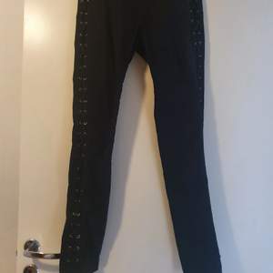 Svarta jeans med snörade detaljer på sidorna 