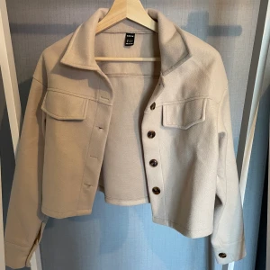 Kort jacka - Kort jacka i beige som liknar ”belted schaket” fast i kort modell, jättefi på men har aldrig kommit till användning, köpt på shein! 