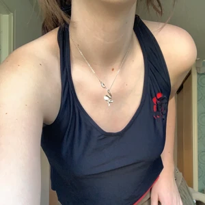 Bikinitop med röd ros på bröstet  - Fin svart bikinitop med ett inre lager av rött. Det finns en röd ros på bröstet och viktigt att tänka på är att även om den är av badklädersmaterial finns det ingen support över huvud taget! Jag har bara andvänd den en gång och då som en vanlig tröja. Skriv privat för fler bilder!<3