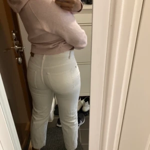 Vita jeans - Hårt material, sitter smalt runt midjan å löst vid benen. Passar strl 38