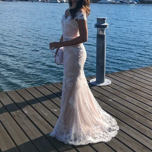 Balklänning - Säljer min sjukt fina balklänning. Nypris: Runt 5000-6000kr, jättefint skick, har kemtvättats efter 1 användning och är som ny. Köpt på DressingRoom Linné i Göteborg. Klänningen har vacker brodyr med små insydda stenar över hela som glimmrar super fint i solen🤍 Off shoulder, lite släp, dragkedja i ryggen, beige/vit, vadderad byst så behövs ingen BH under🥰