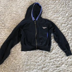 Reebok Zip Up hoodie - Svart Reebok Zip Up hoodie, vit logga på baksidan.