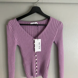 Ribbad topp från NA-KD, storlek xs  - Denna ribbade toppen med knappar är från NA-KD och är aldrig använd, prislapp finns kvar. Säljer pga inte min stil! 