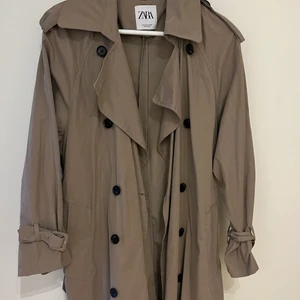 Zara trenchcoat  - Superfin, perfekt trenchcoat från zara! Köpt förra året om jag inte minns fel, men tyvärr aldrig blivit använd. Perfekt skick! I storlek S, väldigt fin passform