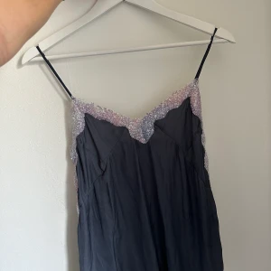 Linne med paljetter  - Jättefint linne med paljetter, perfekt till nyår. Linnet har en otroligt fin färg i en skimmrande effekt så den shiftar i marinblå/grå/lila.  Säljer pga att det blivit förlitet. Sparsamt använd o i därför väldigt fint skick. 