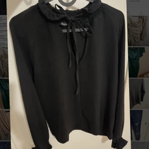 Svart tröja  - Svart tröja öppen vid brösten samt lite vulanger vid armarna använd endast ett par gånger. 