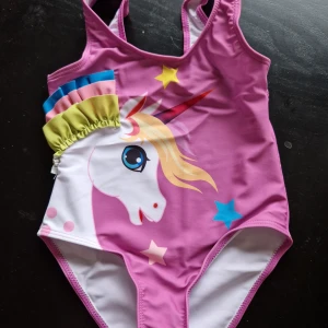 Baddräkt ca strl 98-104 - Baddräkt till barn. Passar ca storlek 98-104. Helt oanvänd, skyddet i grenen kvar.