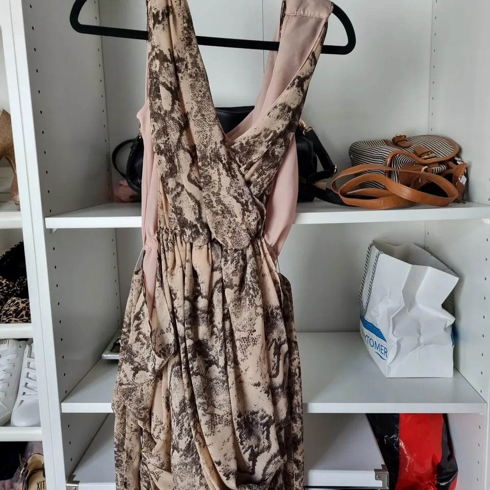Kort festklänning. Ormmönster. Inköpt från HM. Storlek 36. En liten rift framtill på klänningen . Klänningar.