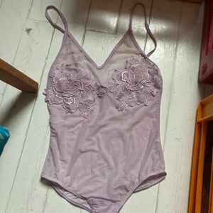Body från Missguided  - See through body från Missguided i rätt bra skick förutom att rosens söm lossnat på ett ställe (se bild). Knappar nertill på bodyStorleken är uppskattad. Katt i hemmet. Kan mötas upp i Uddevalla om ej så står köparen för frakten.  