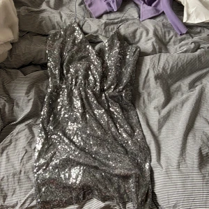 Superfin skriver glittrig klänning - Helt oanvänd med halv öppen rygg.
