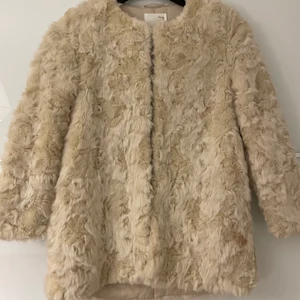 Jacka i vit fuskpäls Zara - Jacka i vit fuskpäls från Zara, storlek 164. Den är köpt från barnavdelningen. Använd ett fåtal gången och är i nyskick. Kan mötas upp i Malmö, annars står köparen för frakt och betalningen sker via Swish. 