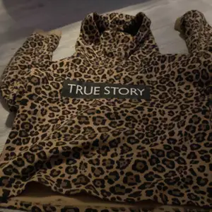 Leopard magtröja med märke där de står ”true story” 