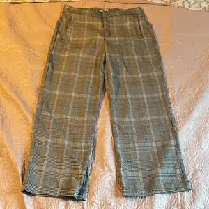 Ett par kostymbyxor med två fickor vid framsidan, cirka 50 cm långa.