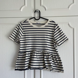 Zara topp  - Säljer denna superfina zara t-djur med volang! Tröjan är knappt använd 