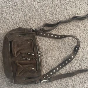 ‼️äkta mocka nunno väska‼️ - 😊säljer denna superfina gråa mocka Nunno väskan. Den är i jättebra skick inga sömnar eller knappar som är trasiga. Köpte den förra sommaren säljer den då den tyvärr inte kommer till andvändning. Köpte väskan för 1700kr. Skriv endast om du är intresserad 😊