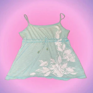 Ljusblått linne - Så sött ljusblått linne med blommor och fina detaljer på 🌺✨ Älskar att man kan knyta under brösten så den sitter fint🤩Står strlk M på lappen men skulle säga att den sitter mer som en S! Priset kan diskuteras🫶🏻 Skriv privat vid intresse o frågor💖💖💋