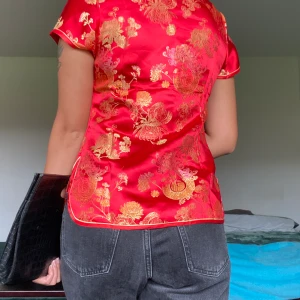Cheongsam blus - Säljer denna pågrund av att den är liten. Det står storlek S men jag skulle säga att det passar en XS. Har endast testat den, men andra ord är den helt ny. Köpte den i sommras. Tyvärr har en knappen tagit till skada. Men det går att fixa med nål och tråd.