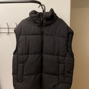 Svart oversized dunväst - Svart oversized dunväst från H&M.🖤 Endast använd några gånger. Strl XS men väldigt oversize, så kan användas av alla från XS-L beroende på hur oversize man vill ha den. Osäker på frakten. Köparen står för frakten. 