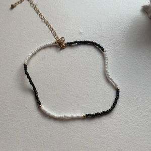 . - Halsband svart vitt, ser lite kort ut men går att variera längd.