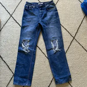 Ett par blå jeans med hål/slitningar på knäna. Köptes för 400kr. Jeansen är ganska oanvända och är därför i bra skick. Köparen står för frakten<3 Om du undrar något är det bara att skriva🧡
